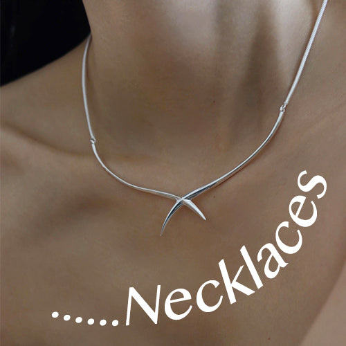 A spiked silver necklace adorns a woman's neck. Original design necklaces.