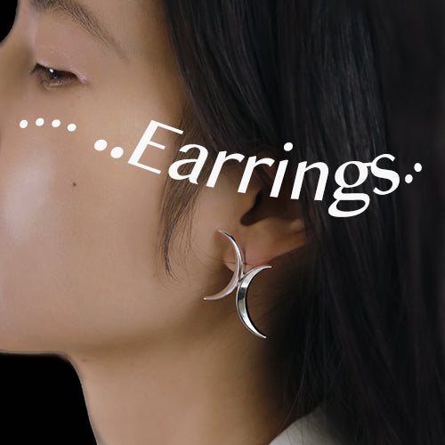 A woman wears a spiked silver earring. Original design earrings.